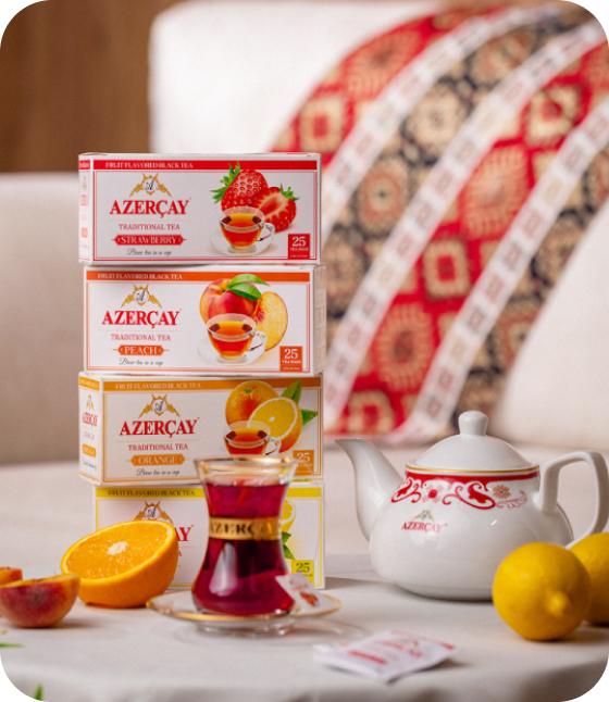 Üst-üstə düzülmüş Azərçay buket çay qutuları, çaydan və armudu stəkanda çay